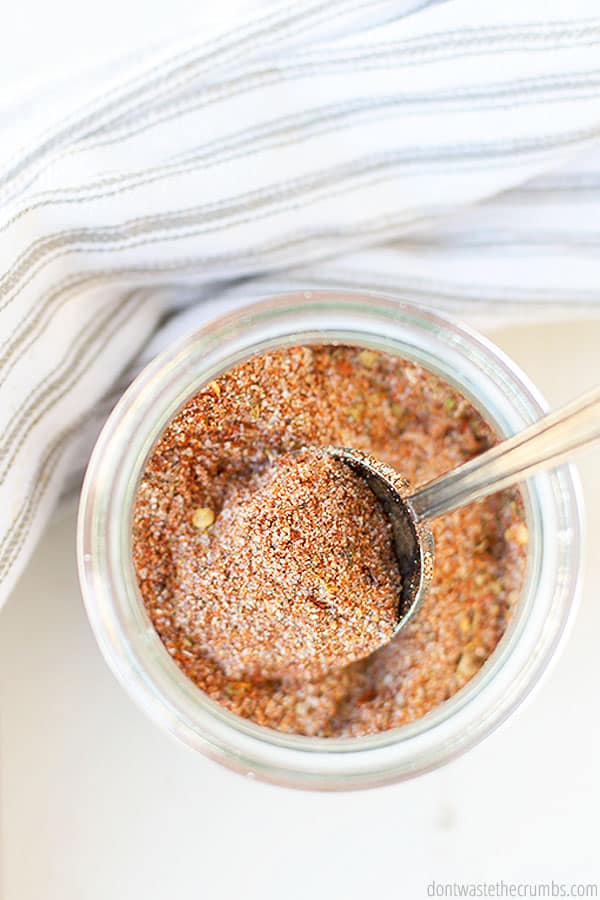 Overview of homemade Cajun seasoning in a spice jar with a spoon.