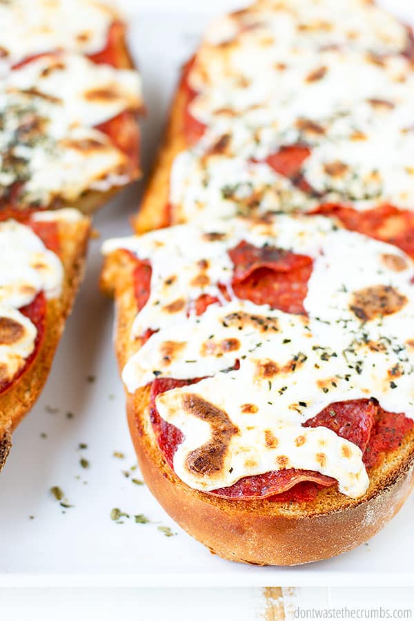 French Bread Pizza baked, sliced, and garnished with fresh dried herbs.