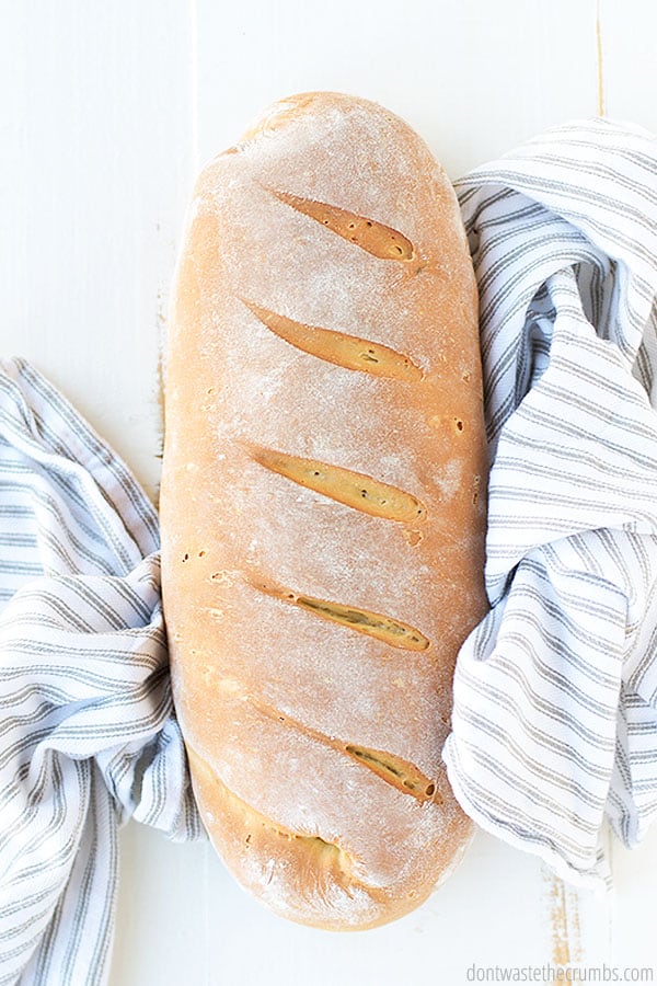 A freshly baked loaf of French bread ready to be sliced and baked into cheesy garlic bread. 