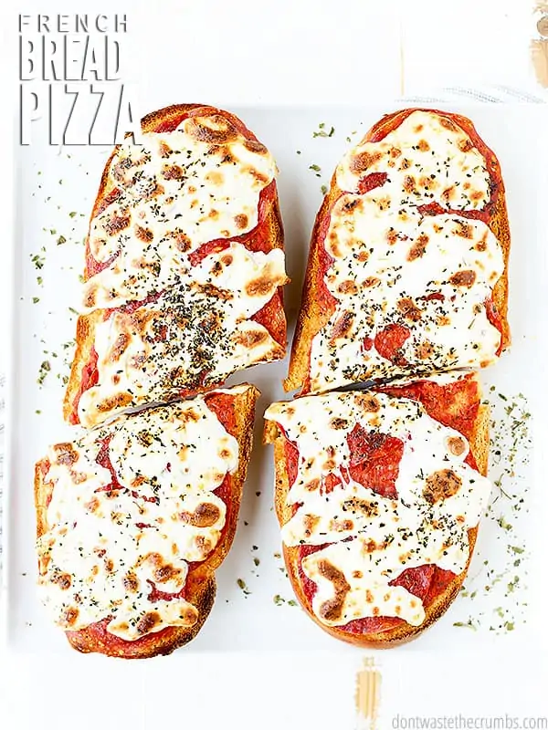 Homemade French Bread Pizza finished with fresh herbs and sliced into serving size pieces. The text overlay reads "French Bread Pizza."