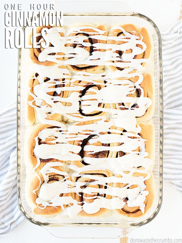 Glass baking dish with 12 freshly gazed, quick & easy, one hour cinnamon rolls. 