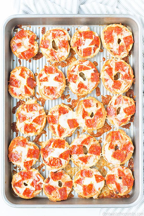 Cooked mini pizza bagels on a baking sheet.