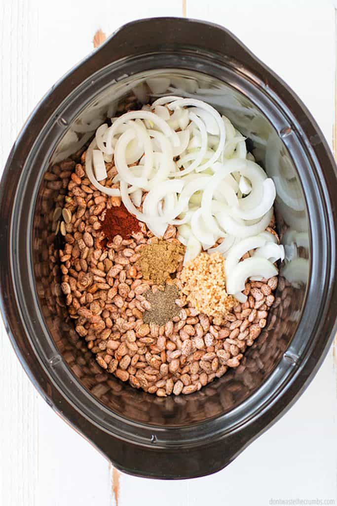 All you need for this crock pot refried beans are pinto  beans, onion, jalapeno, garlic, salt, pepper, cumin, and water! That's it! Try this easy recipe!