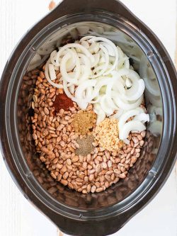 All you need for this crock pot refried beans are pinto beans, onion, jalapeno, garlic, salt, pepper, cumin, and water! That's it! Try this easy recipe!