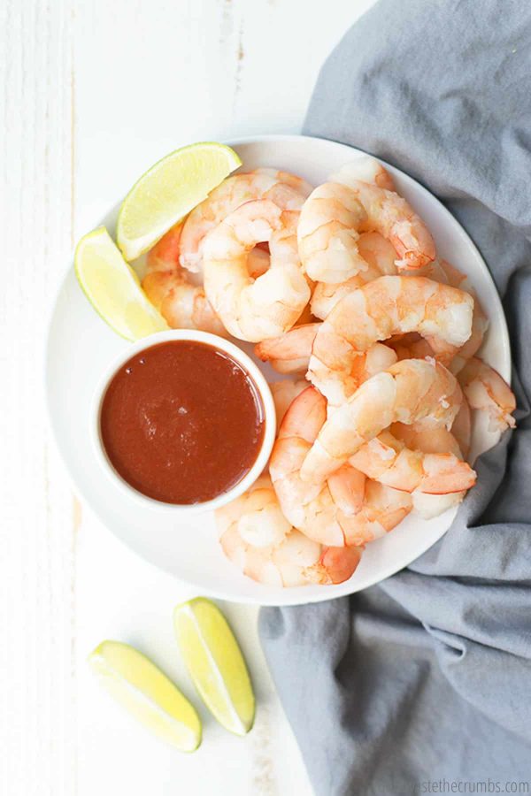 This shrimp instant pot is laid out on a plate with dressing and two lime wedges, makes the perfect meal!