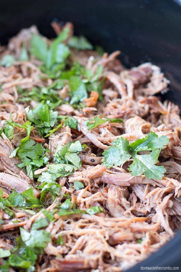 Slow cooker carnitas in a cast iron skillet.