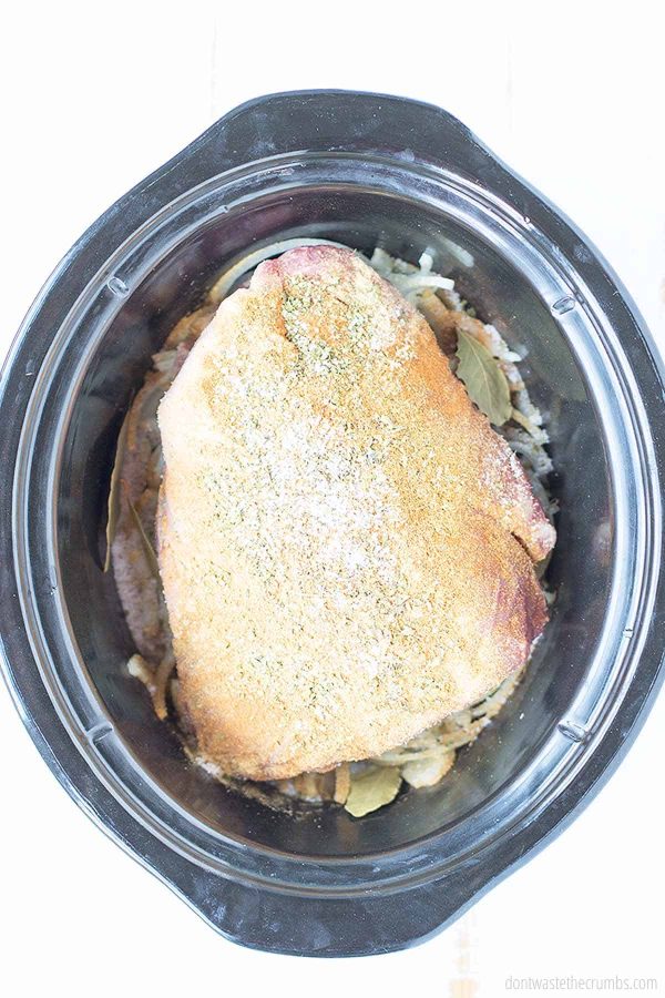 Now you will lay your pork roast on top of the onions in your slow cooker.