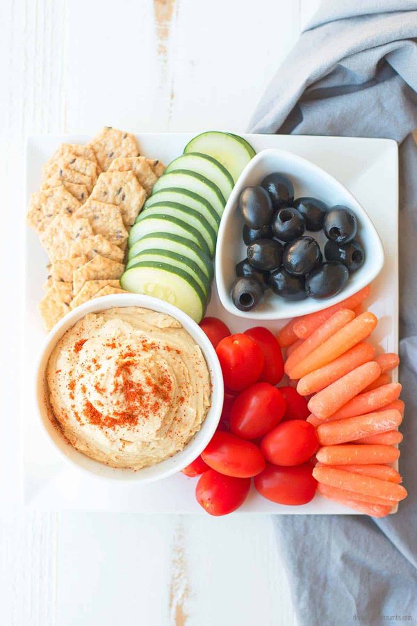 These homemade crackers, fresh cucumbers, carrots, cherry tomatoes, and olivesare all laid out beautifully around homemade hummus. Dig in!