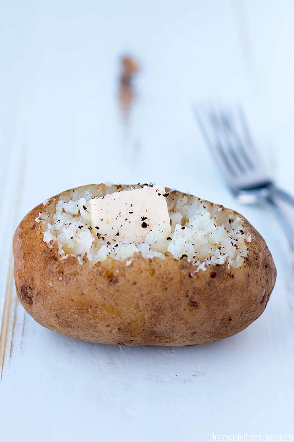 Perfectly baked potato seasoned with salt, pepper and a dollop of butter.
