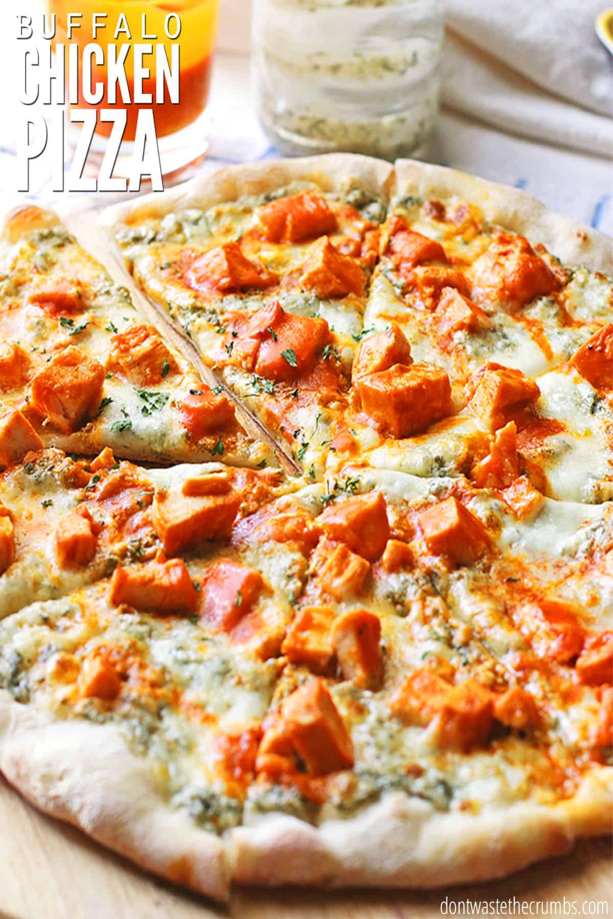 A freshly baked buffalo chicken pizza sliced and ready to eat! The text overlay reads, "Buffalo Chicken Pizza."