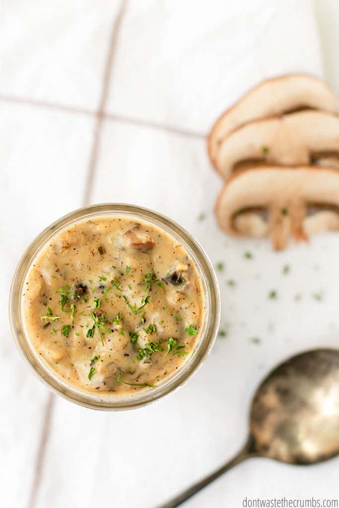 Freshly cooked mushroom soup garnished with parsley, ready to be enjoyed. Serve up in a small jar for a delicious lunch.