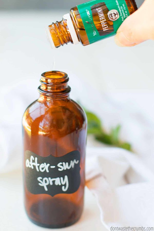 Peppermint essential oil drops are being poured into a glass bottle mister.