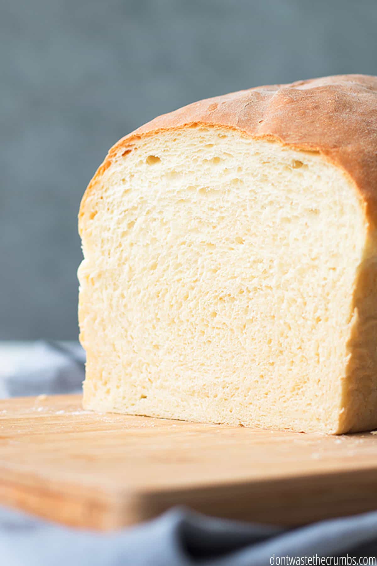 A whole loaf of homemade bread sliced to show the fluffy white interior.