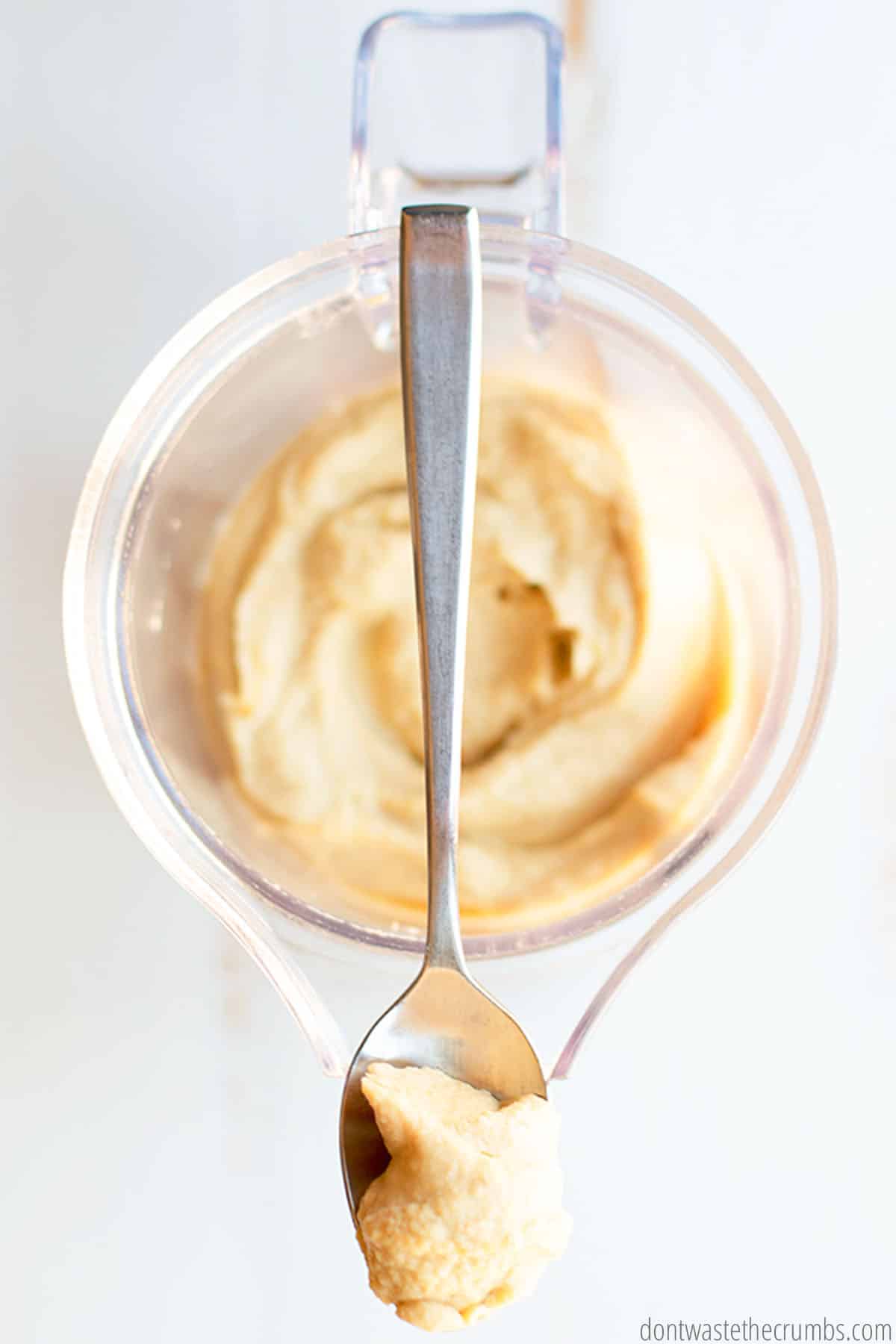 A spoonful of smooth classic hummus after it was freshly blended in a small food processor.