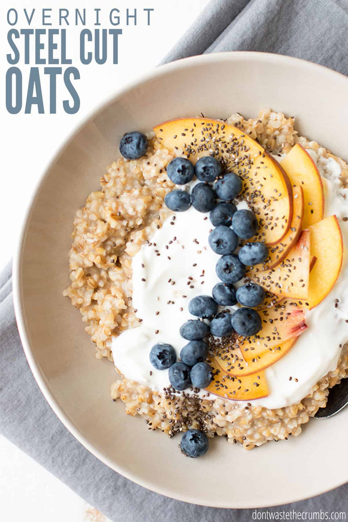 A bowl of steel cut oats is topped with yogurt, blueberries, and peach slices. Text overlay reads "Overnight Steel Cut Oats."