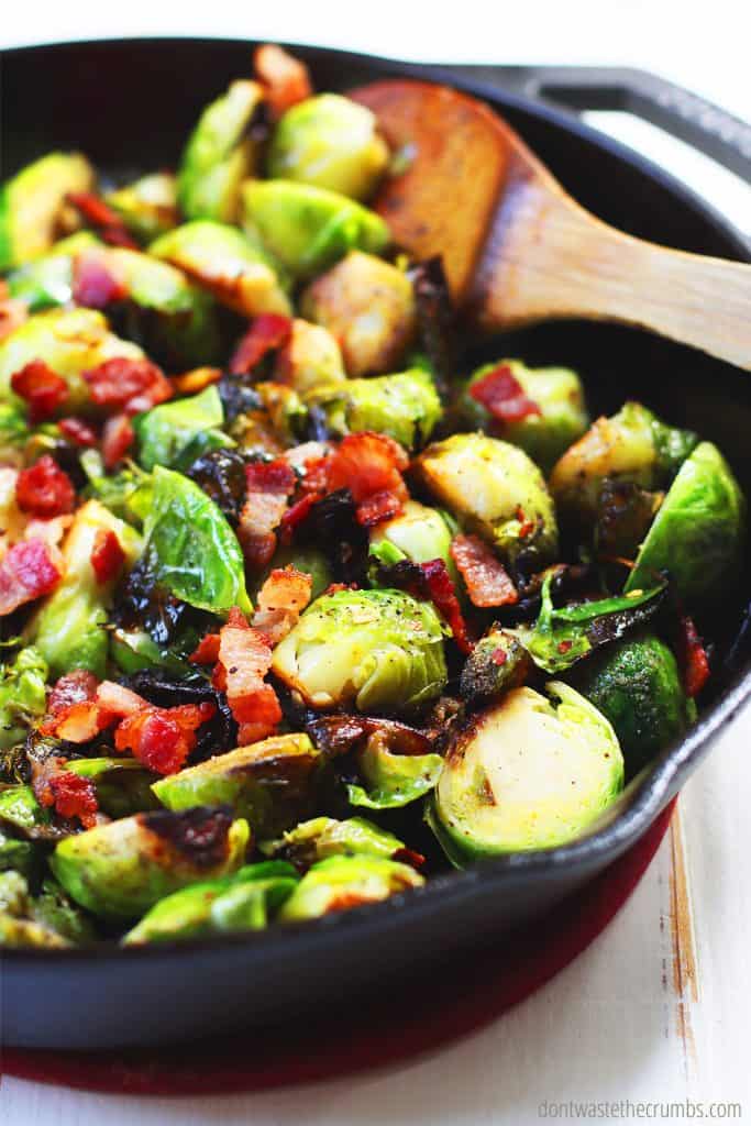 Sliced Brussels sprouts roasted and stirred in a cast iron skillet with bacon, onions, and seasonings. 