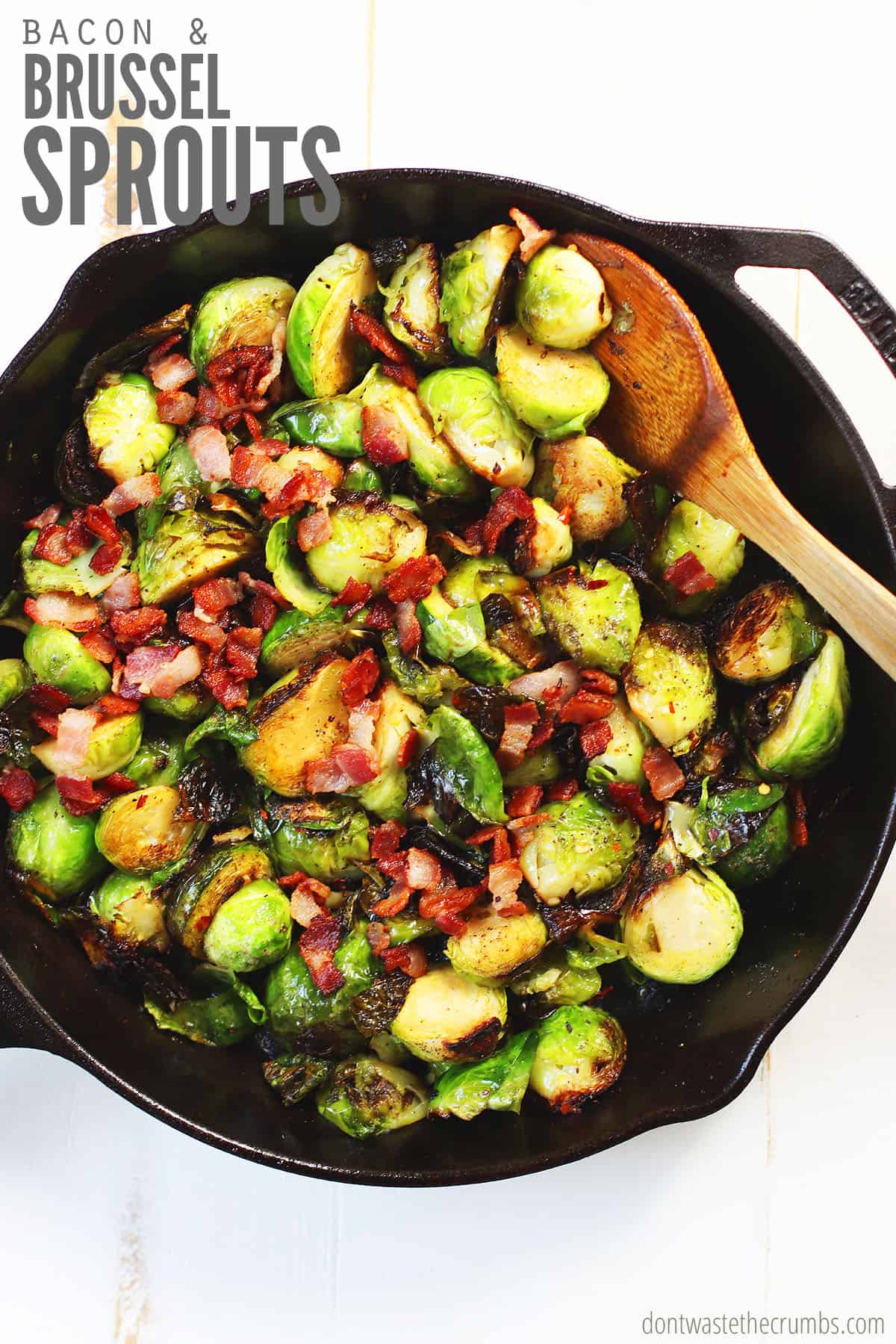 A cast iron skillet with freshly roasted brussels sprouts with bacon and onions. The text overlay reads, 'Bacon & Brussel Sprouts.'