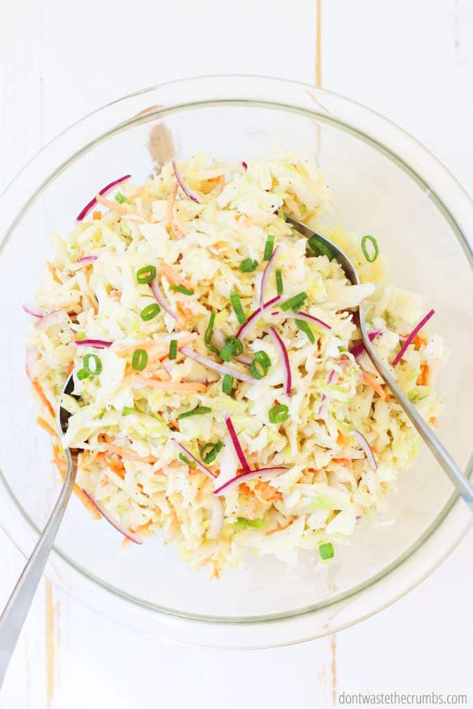 Freshly mixed homemade coleslaw with two spoons ready to serve. 