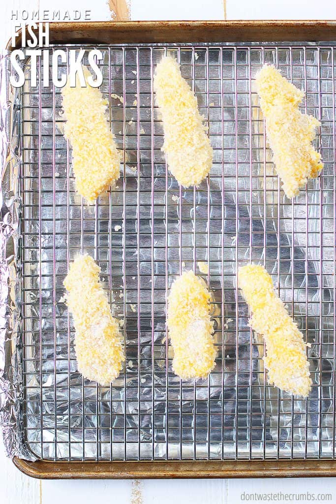 Panko breaded fish sticks on a wire rack ready to be baked in the oven. The text overlay reads 'Homemade Fish Sticks." 