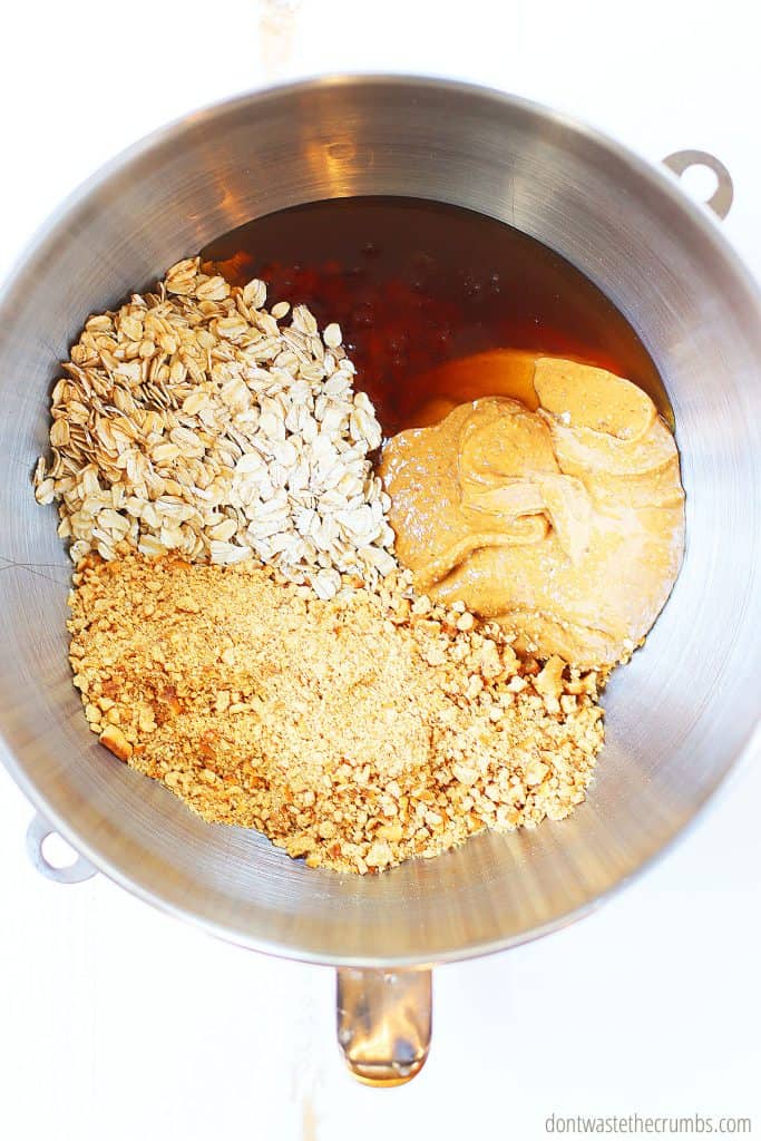 There is oatmeal, crushed pretzels, honey, peanut butter, and oats in a pot. These are some of the ingredients that you need for peanut butter granola bars.
