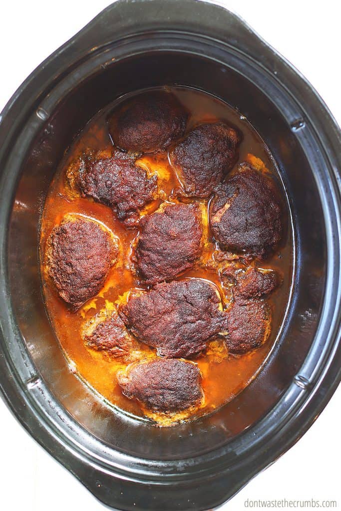 The slow cooker has finished cooking the shawarma chicken thighs with a delicious spiced char in its rich, flavorful sauce. 