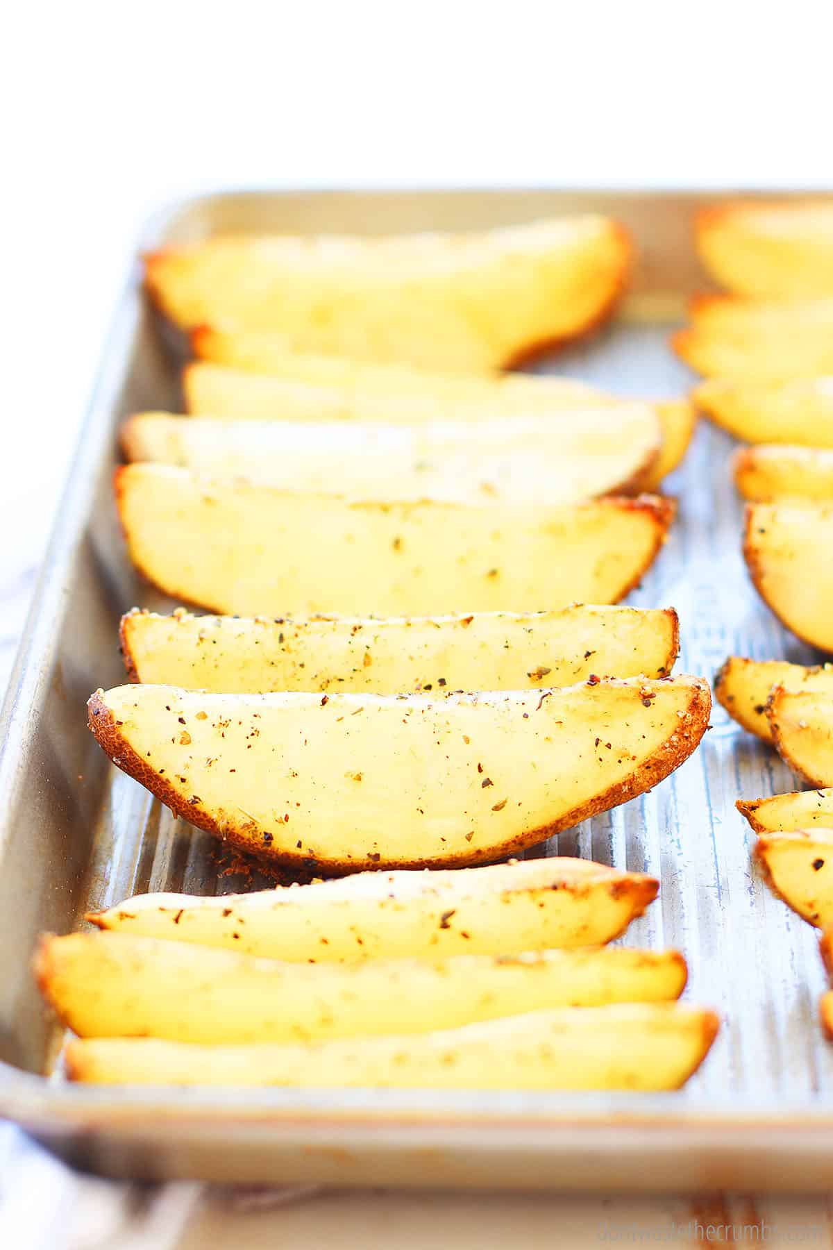 Homemade potato wedges on a baking sheet