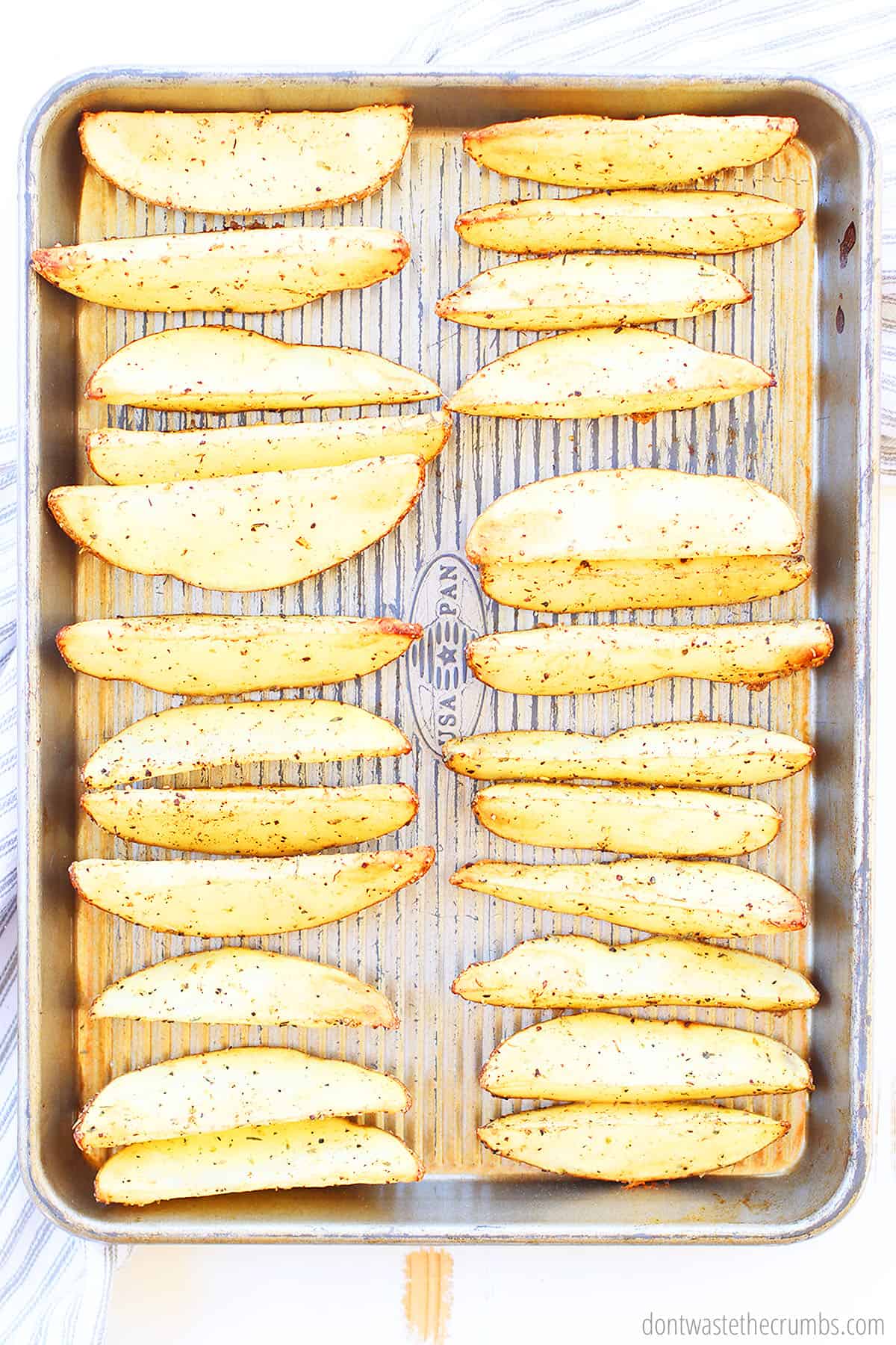 Seasoned potato wedges on a baking sheet