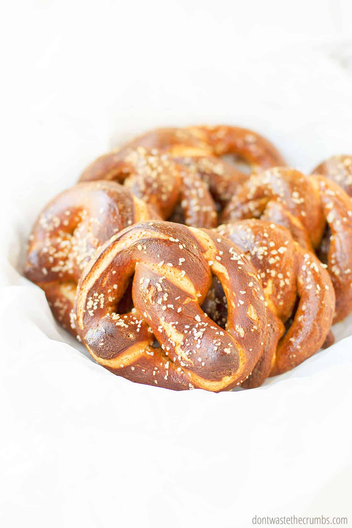 A plate of freshly baked perfectly golden brown homemade soft pretzels.