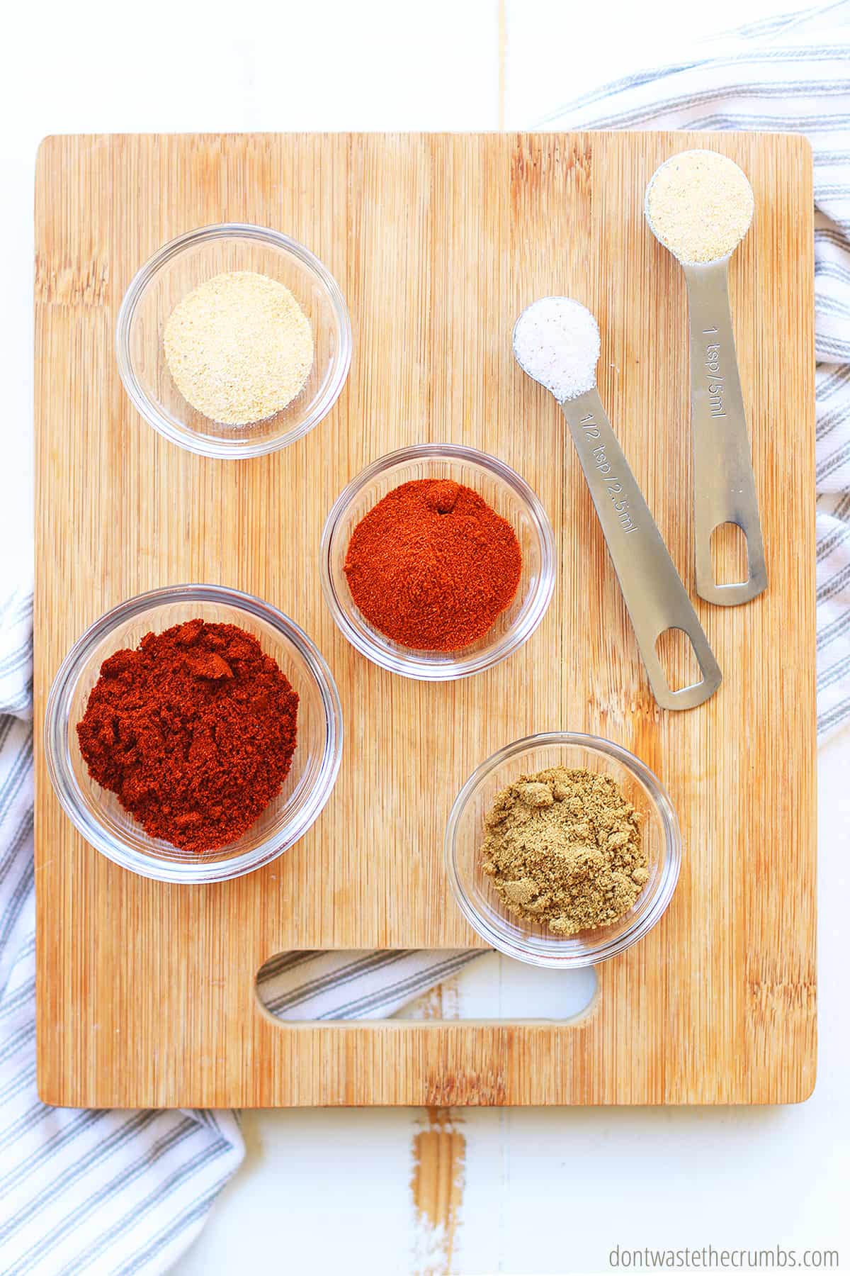 Chili powder, onion powder, paprika, cumin, salt, garlic powder ready to be mixed into fajita seasoning. 