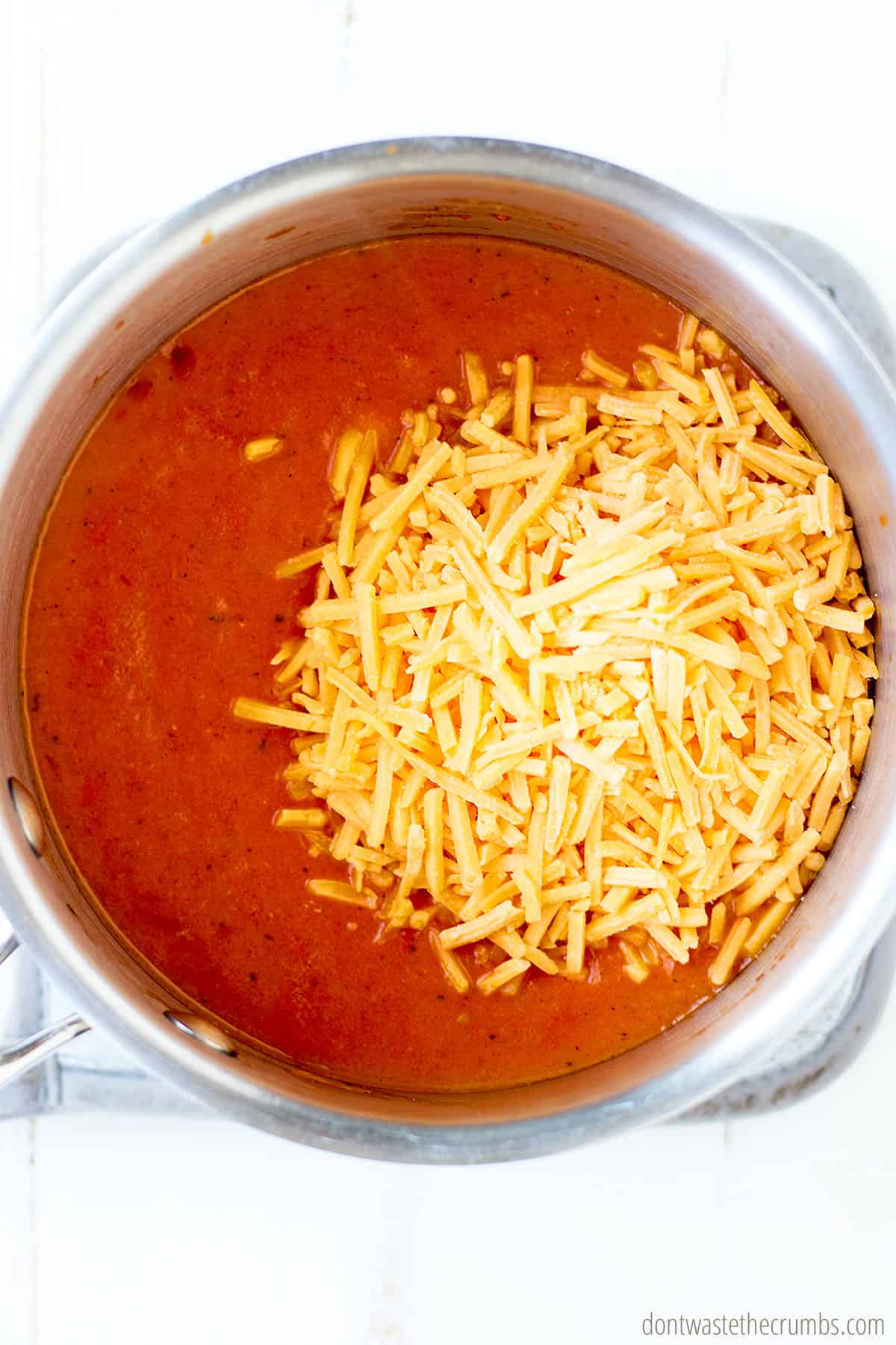 Add shredded cheddar cheese to homemade sauce for spaghetti o's.