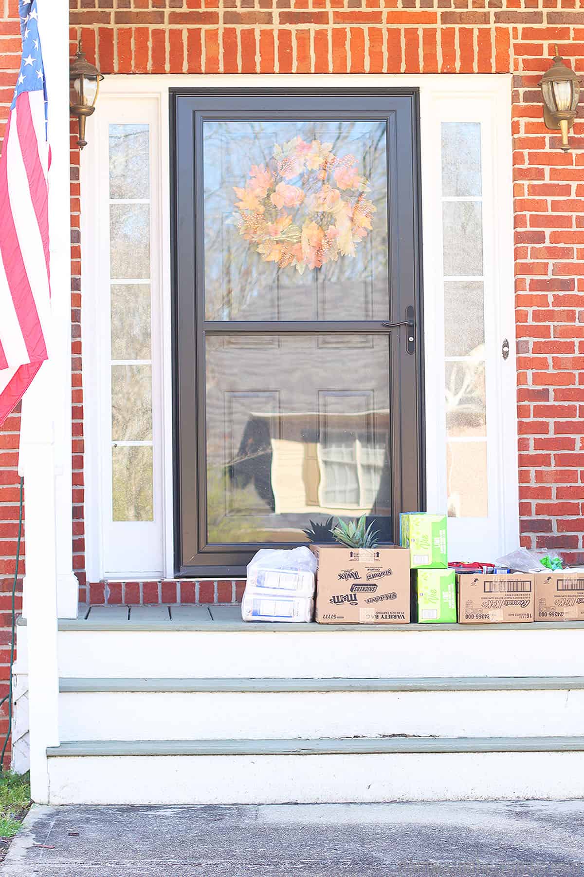 A front porch with groceries left at the door after ordering grocery delivery.