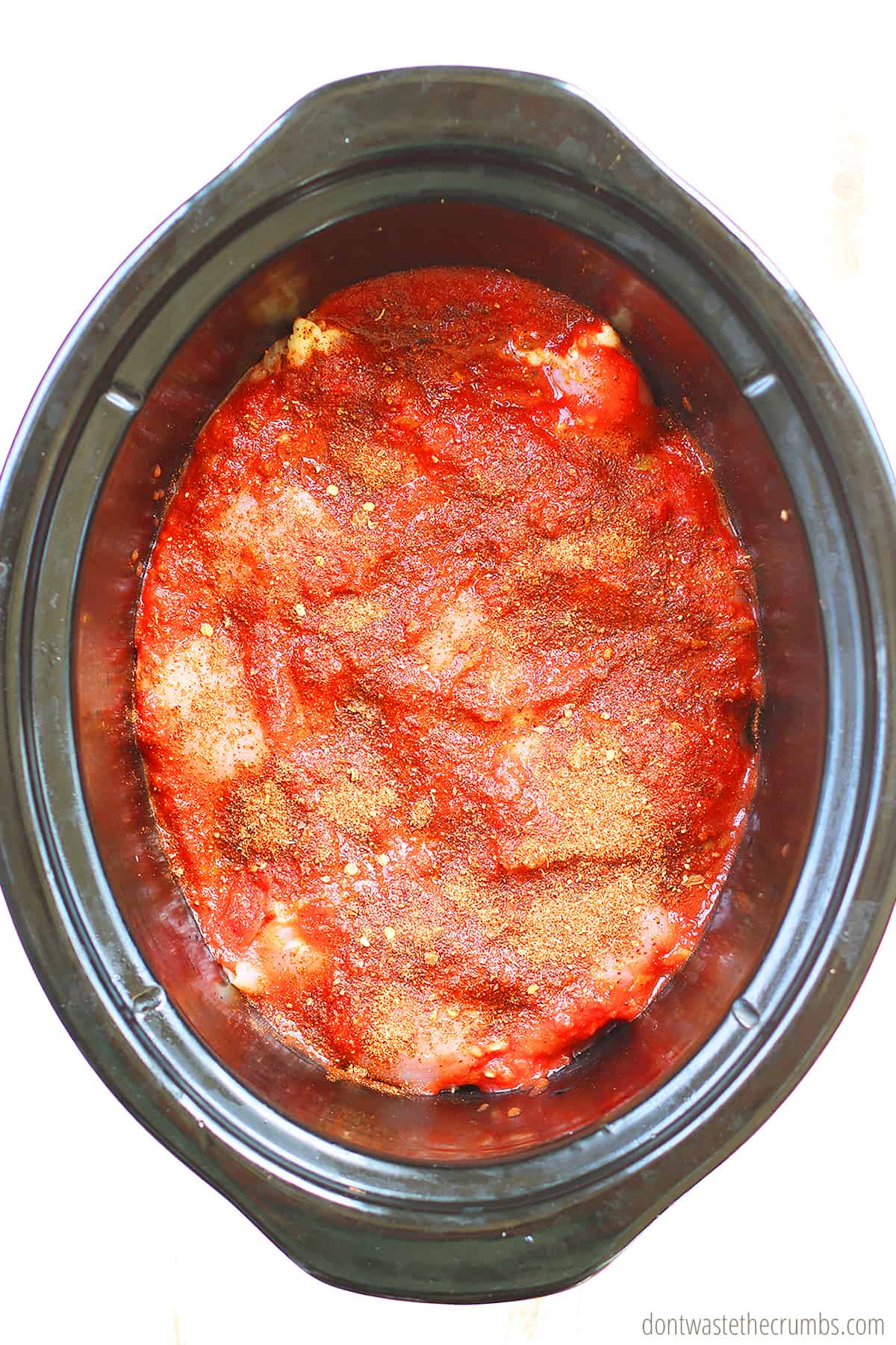 Chicken and salsa in a slow cooker.