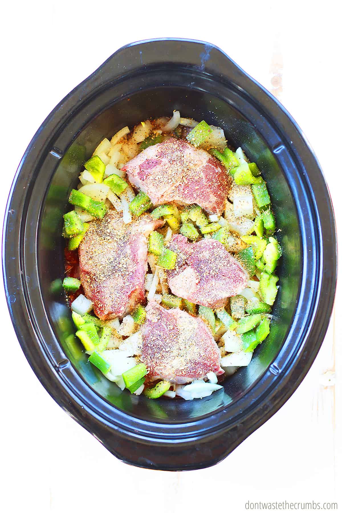 Transfer your seared meat (beef, pork or veal shank) to your crock pot insert and add your vegetables (onions, garlic, tomatoes, carrots) with your seasonings and herbs.