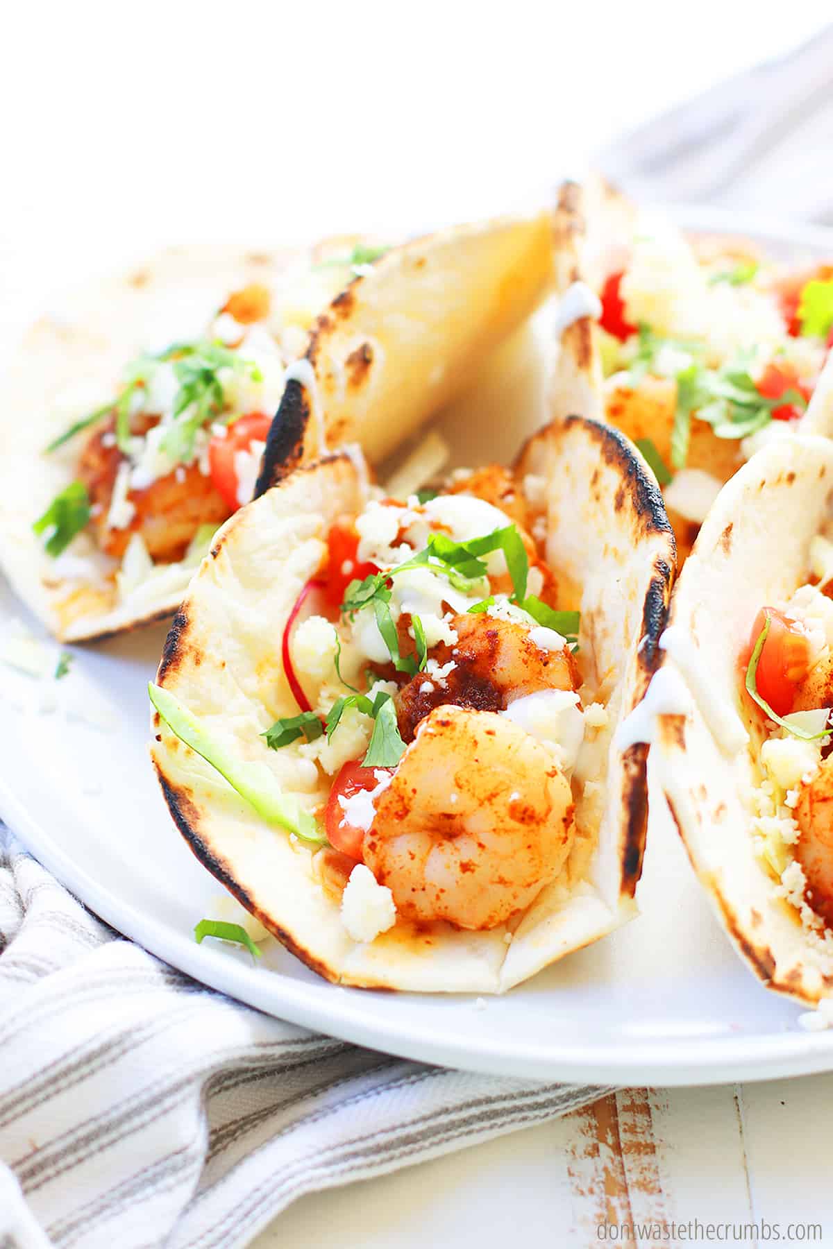 Spicy shrimp tacos on a white plate