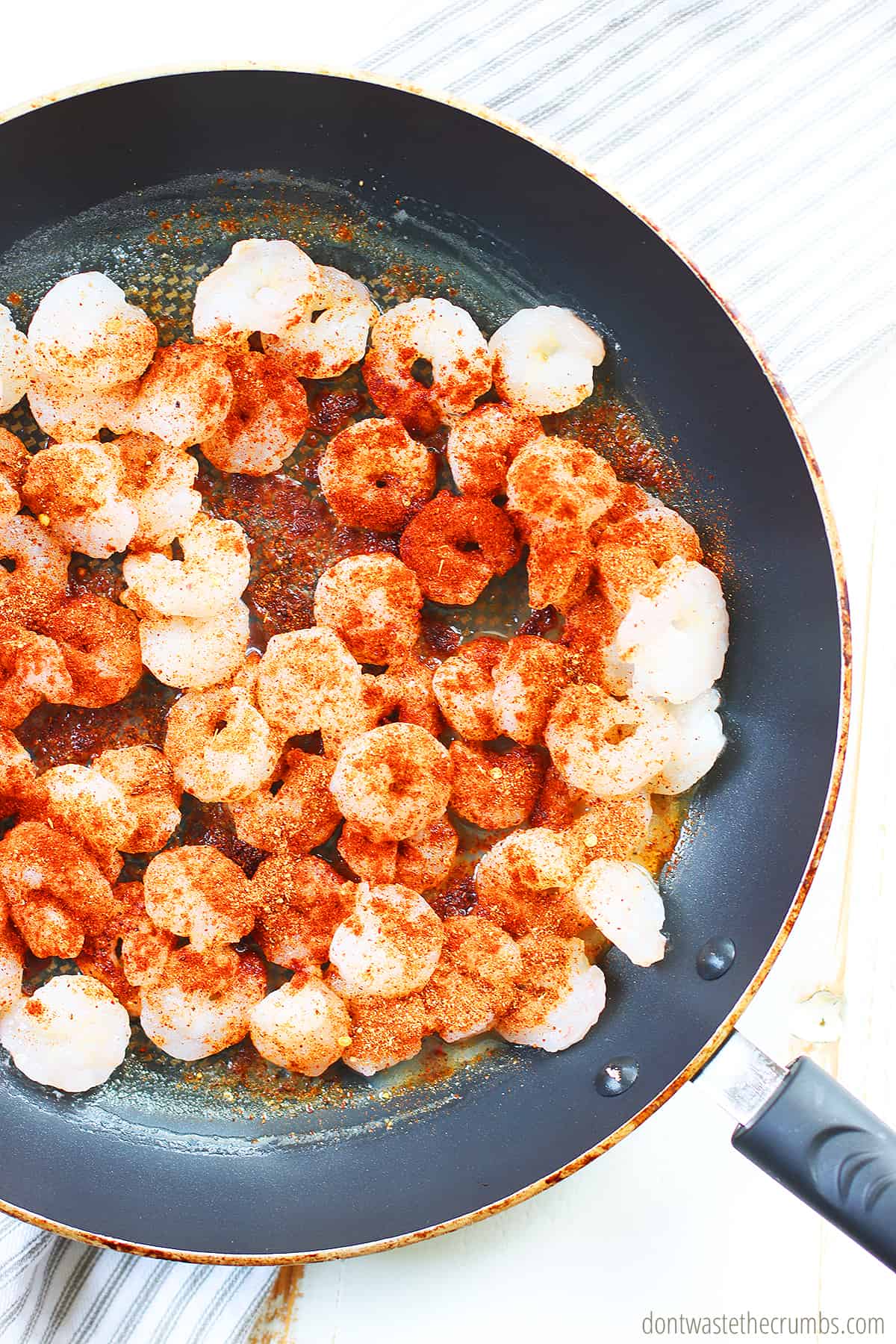Shrimp frying in a pan with seasoning