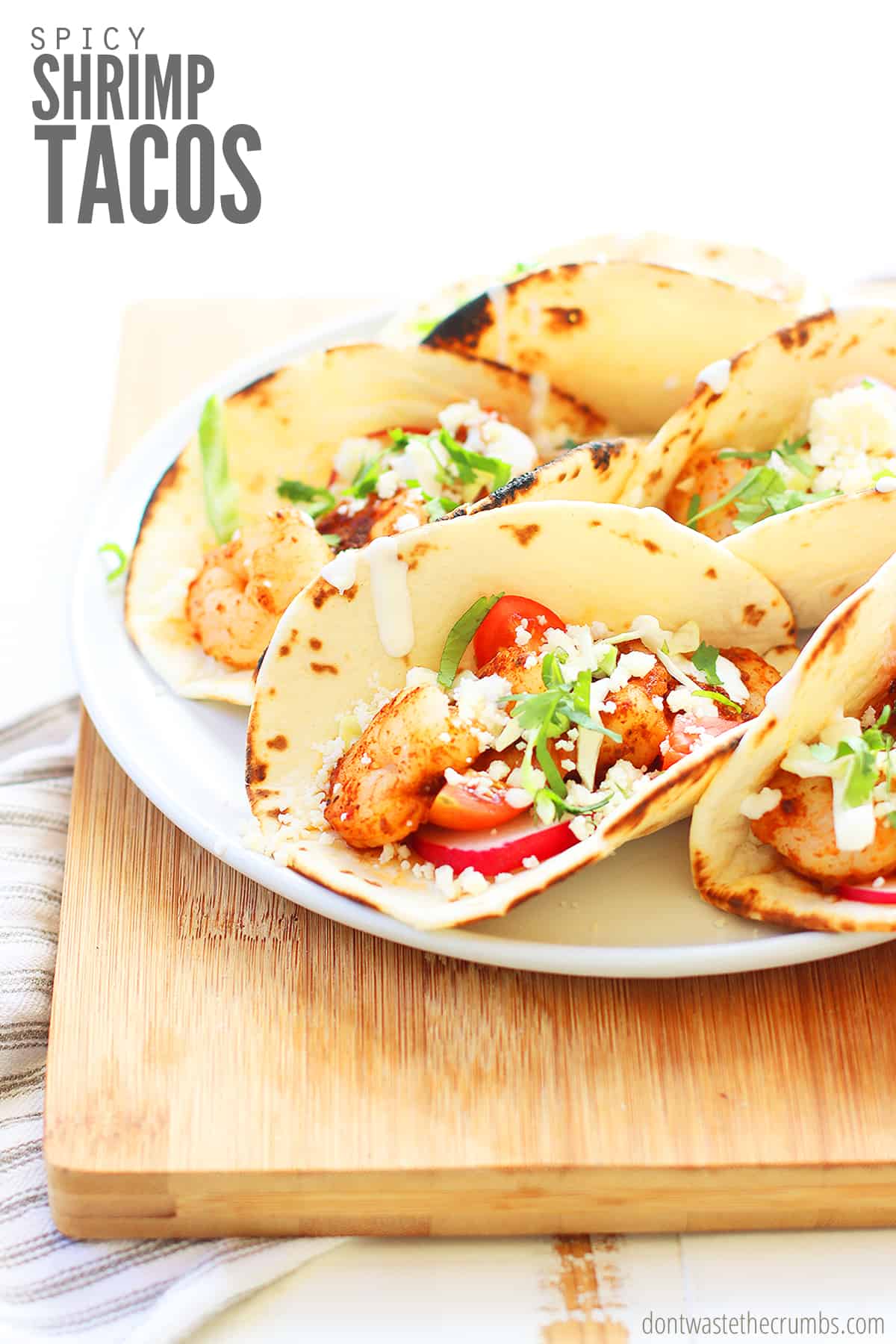 Spicy shrimp tacos and creamy slaw tucked into flour tortillas are loaded with tangy cotija, creamy avocado, and juicy mango salsa in this easy shrimp tacos recipe! Ready in under 30 minutes!
