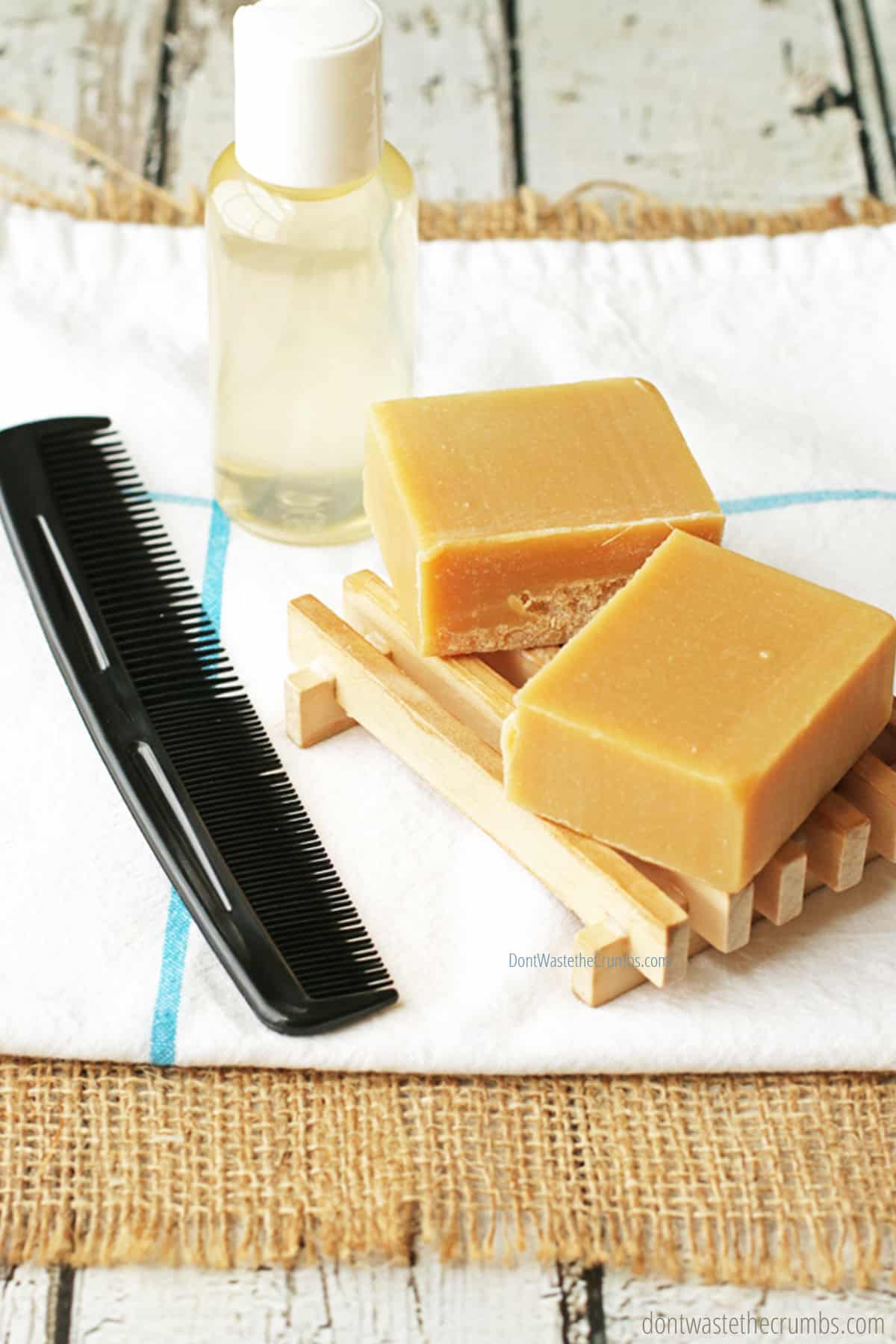 Two bars of goat milk soap, a bottle of liquid soap, and a black comb