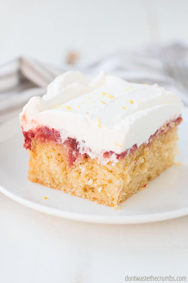 A fresh slice of strawberry poke cake with homemade whipped topping. 