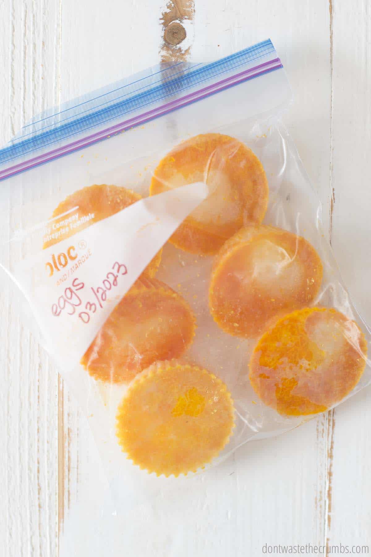 A freezer bag filled with frozen eggs and labeled with a name and a date. 