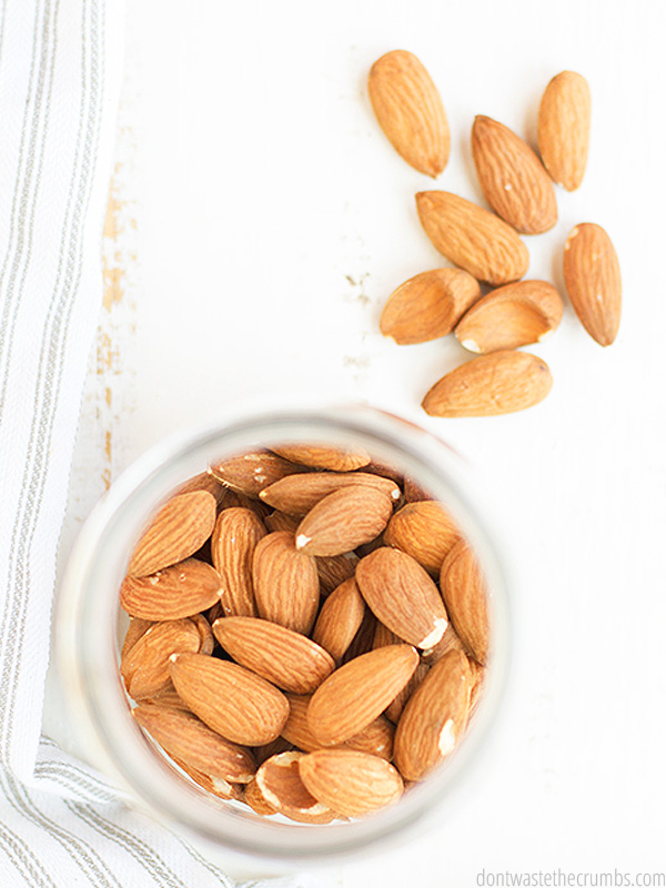 Image showing almonds in a glass jar with a white background.