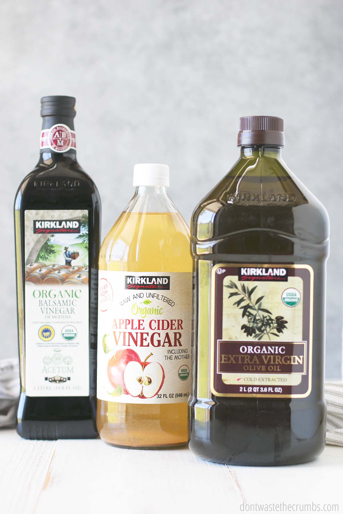 Containers of balsamic vinegar, apple cider vinegar, and olive oil from Costco
