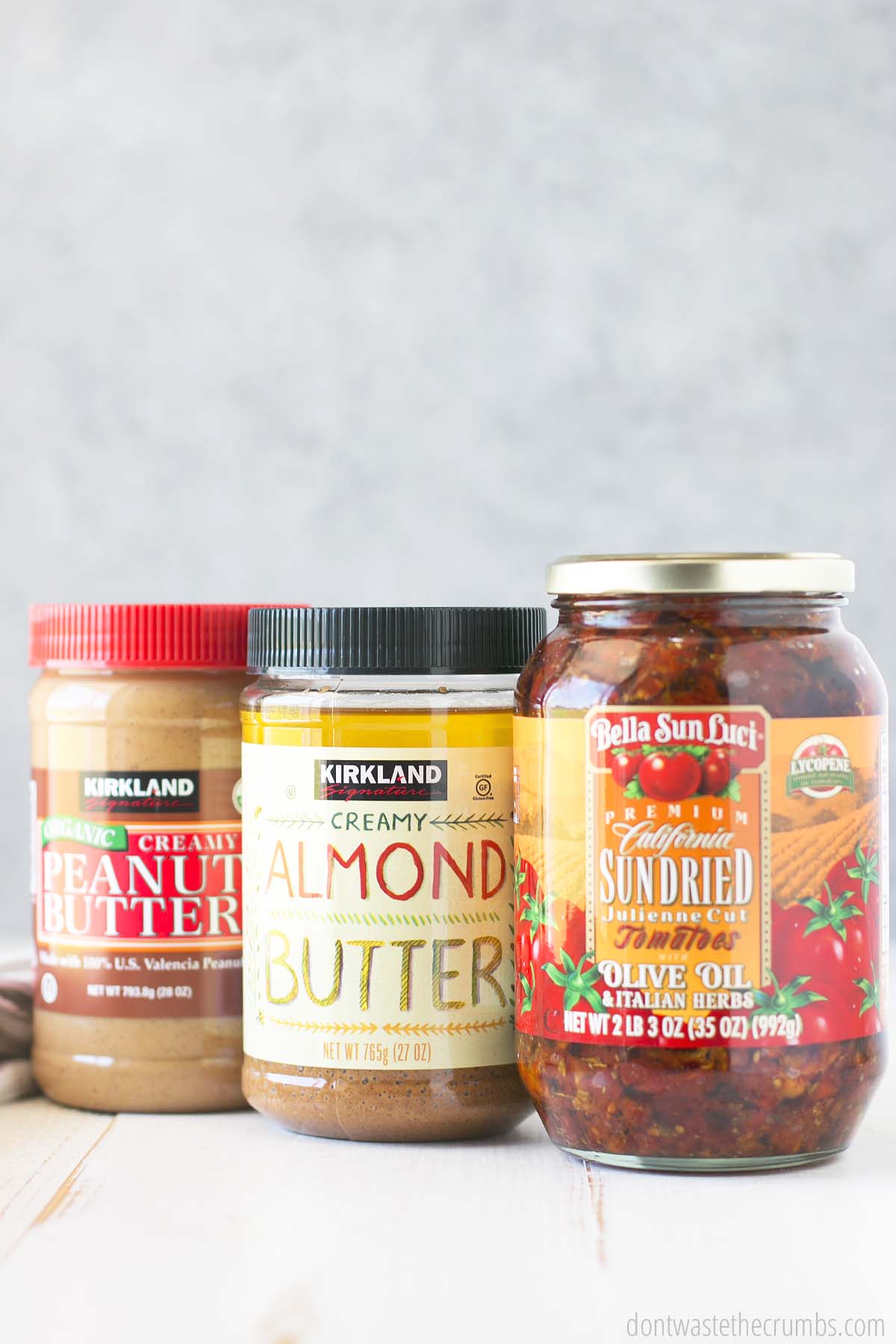 Pantry staples from Costco, including organic peanut butter, almond butter, and a jar of sun-dried tomatoes