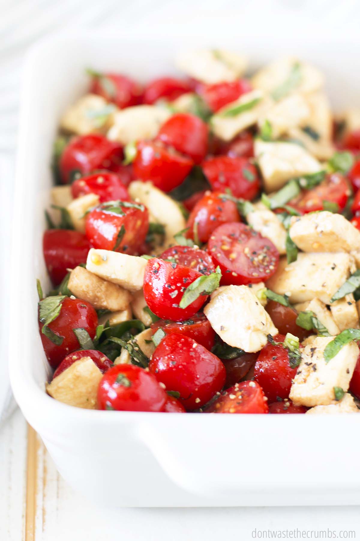 Caprese salad in a white baking dish.