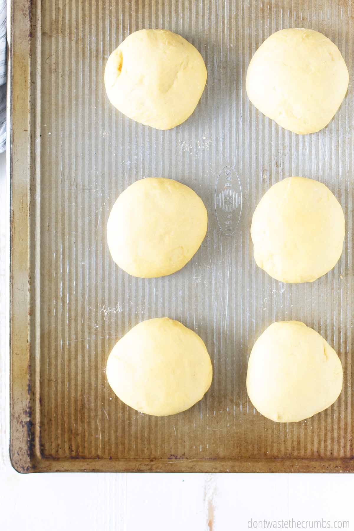 Six balls of dough on a baking pan,