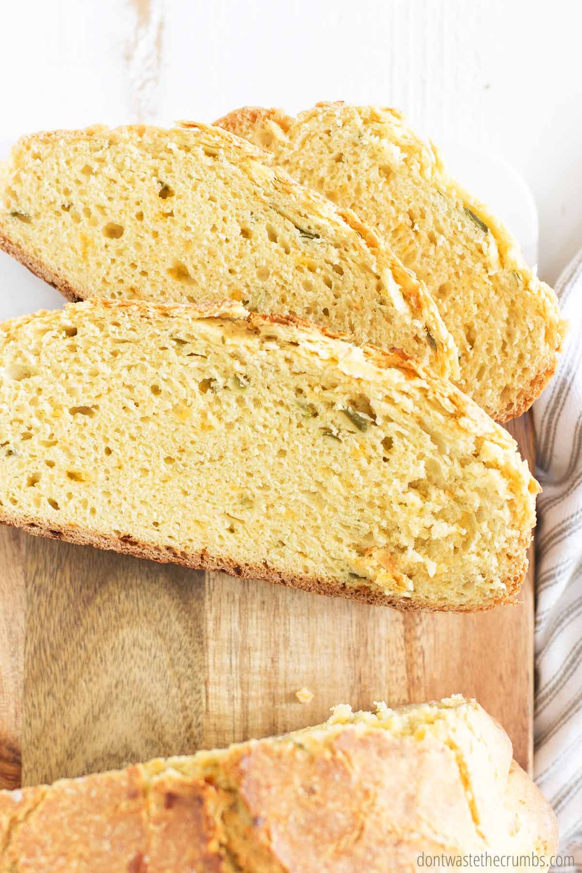 Sliced jalapeno cheese bread on a cutting board, ready to be enjoyed with soup or as a sandwich.