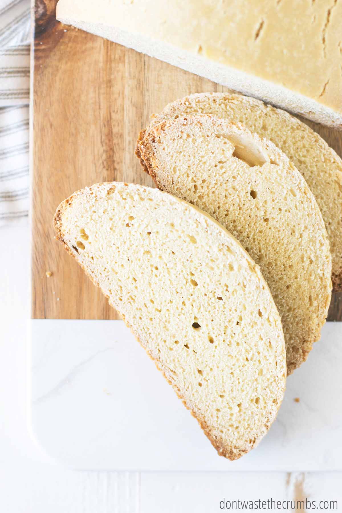 Close up view of half loaf and homemade slices of bread on a cutting board.