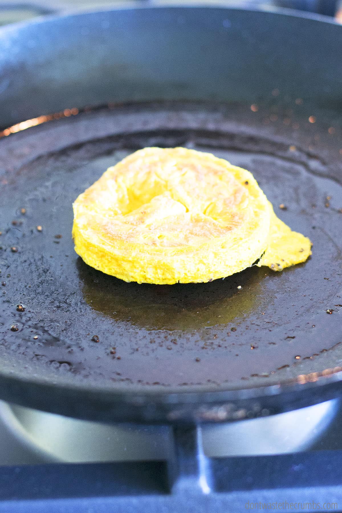 Cooked egg in a circle shape on a skillet.