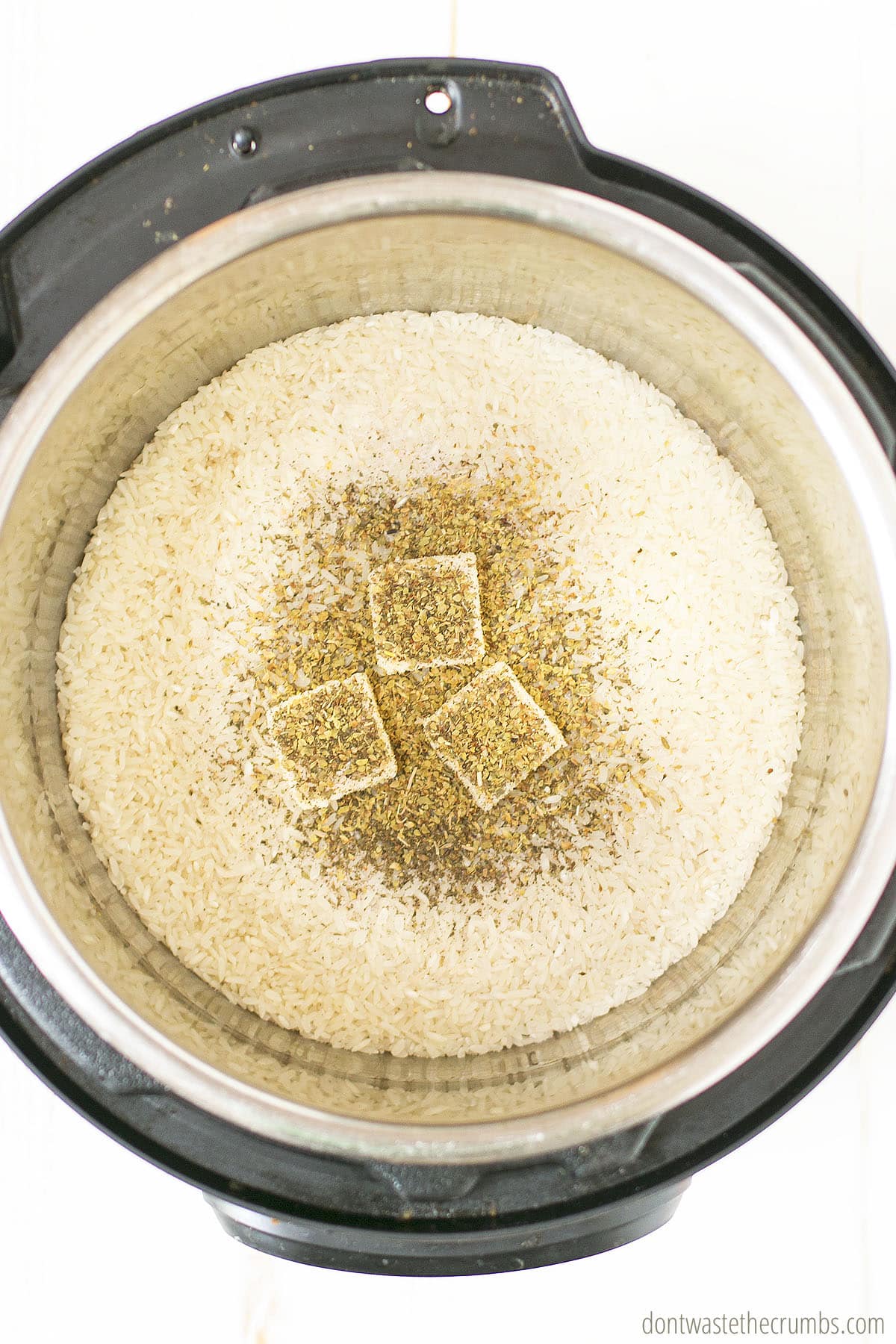 Uncooked rice and seasoning in an Instant Pot.