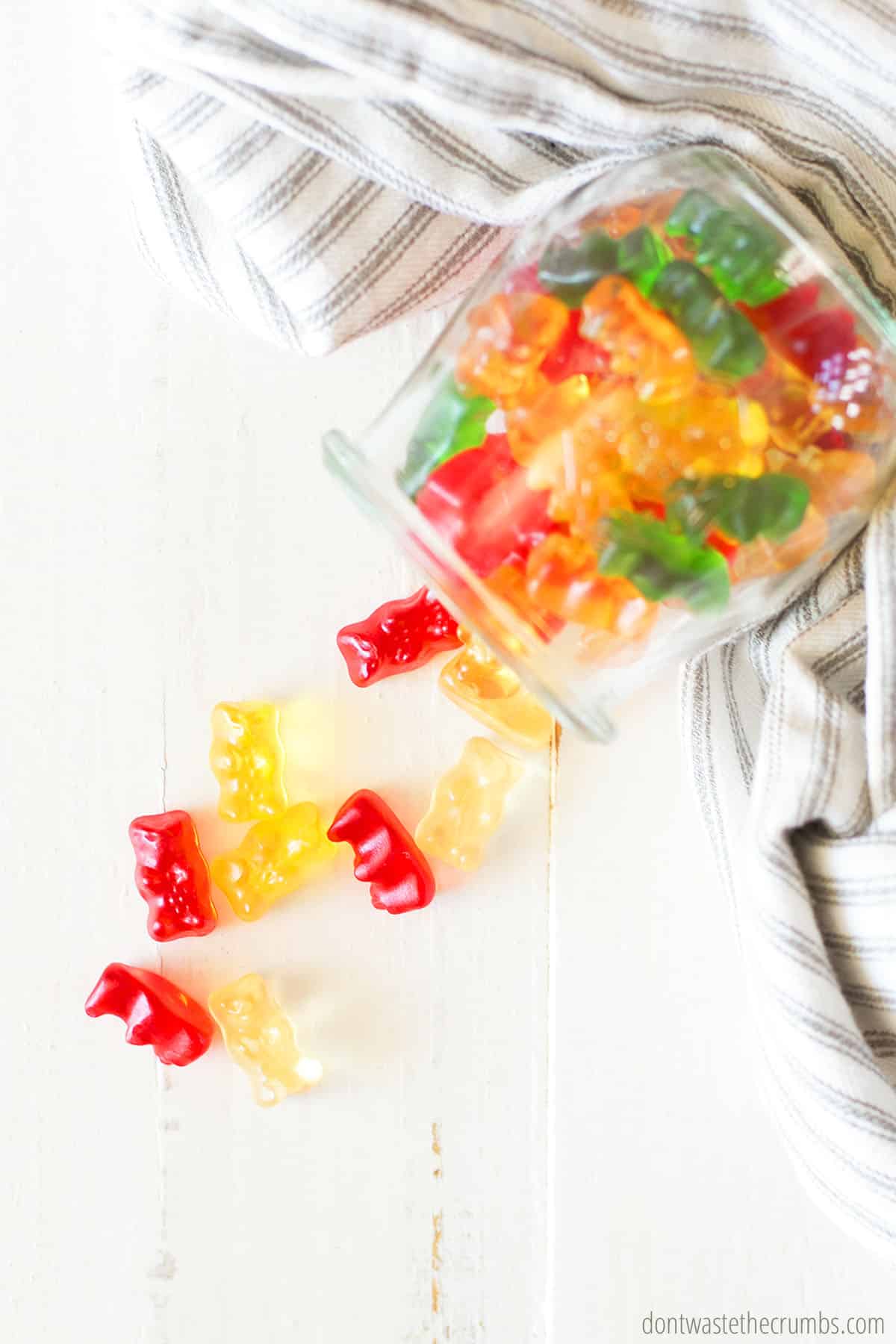 Glass jar tipped over with gummy bears spilling out