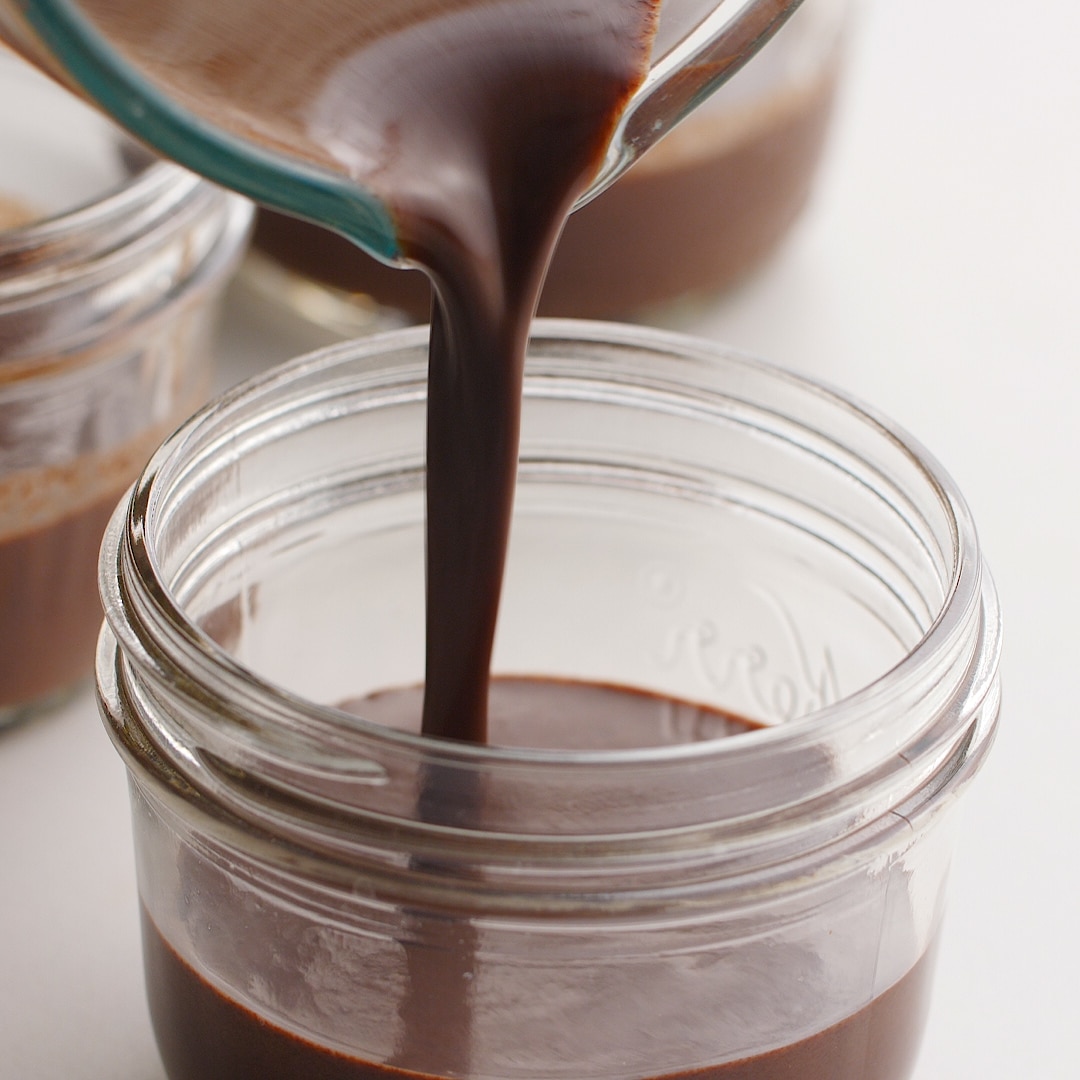 Laddle pouring homemade chocolate pudding into a mason jar